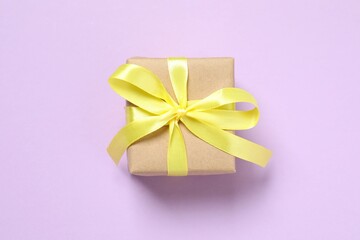 Beautiful gift box tied with bow on color background 