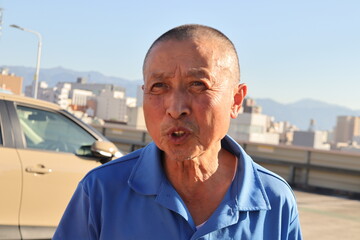 説明する険しい顔の日本人シニア　注意する