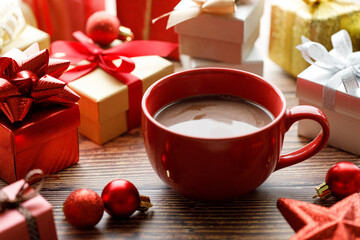 Cup of hot cocoa among vivid gift boxes