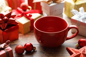 Cup of hot cocoa among vivid gift boxes