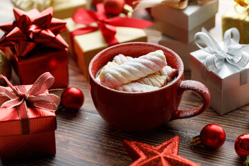 Cup of hot cocoa among vivid gift boxes