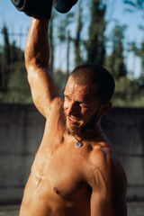 Muscular bodybuilder guy doing exercises with dumbbell