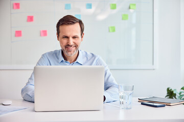 Businessman working at office desk using laptop