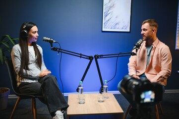 Show host interviewing woman during live stream, talking about fashion and style trends,...