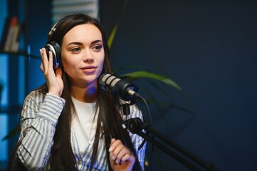Side view of successful woman hosting podcast interviewing man while recording with professional...