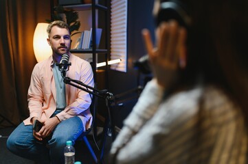 Happy podcasters man and woman shaking hands after recording podcast.