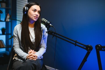 woman records podcast, speaking into microphone