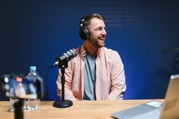Man smiling while recording podcast in studio