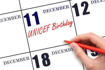 December 11. Hand writing text UNICEF Birthday on calendar date. Save the date.