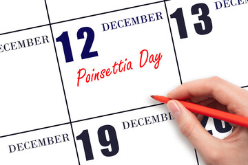 December 12. Hand writing text Poinsettia Day on calendar date. Save the date.