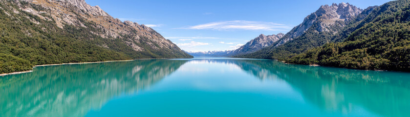 Fototapeta premium Breathtaking turquoise lake surrounded by mountains and lush greenery
