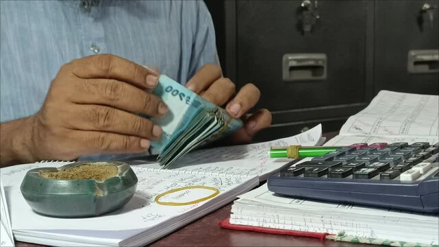 A cashier counts money at a microfinance institution in Bangladesh. 