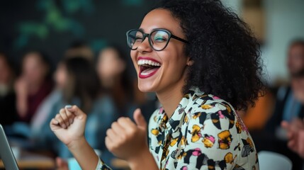 A young woman with glasses and a vibrant patterned shirt laughs with unrestrained joy, celebrating a personal triumph. Her infectious happiness is contagious.