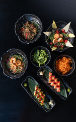Japanese dishes on plates, beautiful presentation of sushi and wok and rice with vegetables and other Asian food in Asian style