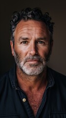 Obraz premium A man gazes directly at the camera, showcasing a serene expression and confident demeanor