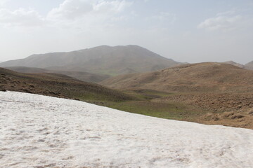 Vast mountainous landscape with patches of snow under a clear sky
