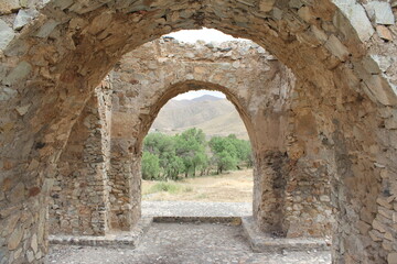 Perspective view of multiple stone arches from an ancient structure, showcasing architectural depth.