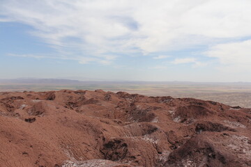 Vast, barren landscape with desert soil under the blue sky, showing the solitude of this empty wilderness.