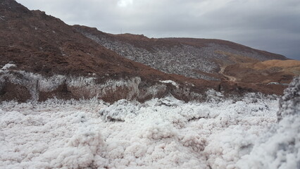 A snowy mountain peak surrounded by a barren landscape, creating a dramatic contrast.