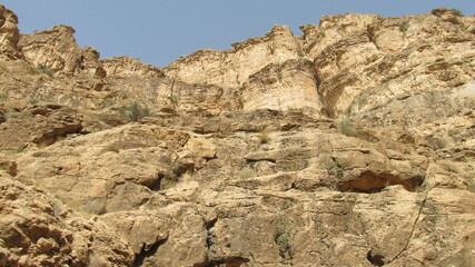 Rocky mountain terrain under clear sky, representing rugged natural landscape and wilderness.