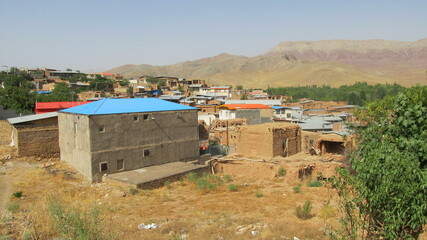 Rural area with a simple house and greenery around, showcasing traditional lifestyle and natural surroundings.