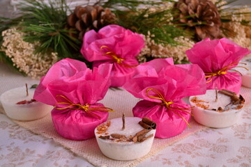 Christmas gifts decoration white candles red wrapping paper golden ribbon, pine tree cone background, new year party souvenirs, winter wedding favors, holidays diy crafting