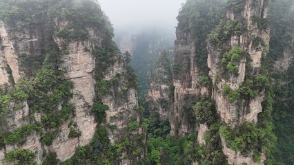 Fototapeta premium Aerial drone shot capturing Zhangjiajie’s mystical peaks and cloudy landscape in China, famously inspiring the Avatar movie’s floating mountains