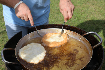 cook preparing deep fried fritters at a traditional peasant food festival