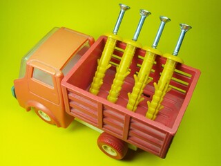 Toy truck. Delivery of building materials. Dowel, screw and self-tapping screw. Accessories and fasteners
