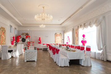 The design of the hall for the anniversary. Red and white colors in the restaurant at the birthday party.