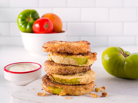 US southern food of fried green tomatoes in a kitchen scene with dipping sauce; copy space