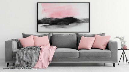 A large gray couch with pink pillows and a blanket draped over it