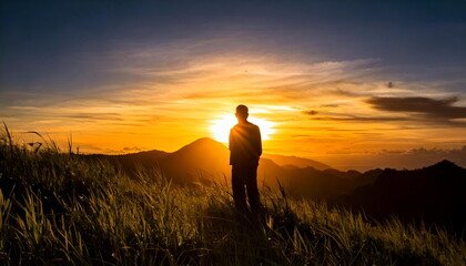 silhouette man standing on the hill with sunset view