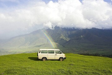 Obraz premium Adventure road trip van under rainbow mountain landscape nature photography green hills scenic view freedom and exploration