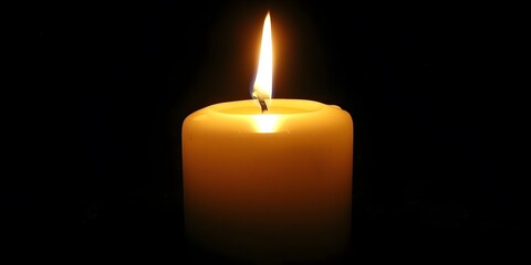 A lit candle emits a warm glow against a dark background, symbolizing light and tranquility.
