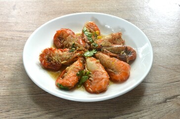deep fried salty river shrimp with chop garlic and pepper in fish sauce arranging on plate 