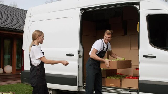 Harvest delivery to fruit market on food truck by loader, transport service to grocery selling from industrial farm plant. Workers carrying boxes of apple, transfer supply of foodstuffs on lorry van