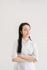 Confident Young Woman in White Shirt Posing Against Minimalist White Background with Arms Crossed and a Calm Expression