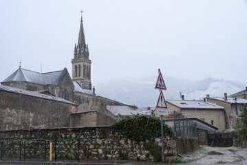 Old Cornas village under the snow with white snow covered vineyard on the background.