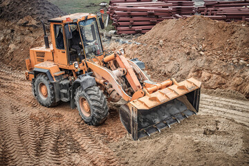 Heavy machinery works efficiently at a construction site, leveling ground at a new building...