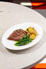 Portion of grilled top blade steak with potatoes and spinach