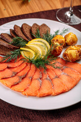 Smoked salmon platter appetizer with bread and potato