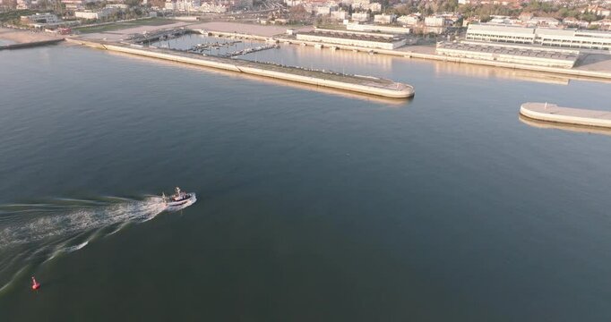 Aerial drone shot of fishing boat coming into port at the Doca de Pedrou&ccedil;os marina in Belem, Lisbon, Portugal, Europe. Golden hour before sunset. Shot in ProRes 422 HQ