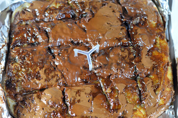 a flaky Egyptian layered pastry, stuffed with chocolate baked dessert and cookies and topped with brown chocolate paste and sauce, Feteer meshaltet cushioned pie stuffed with brownie and chocolate