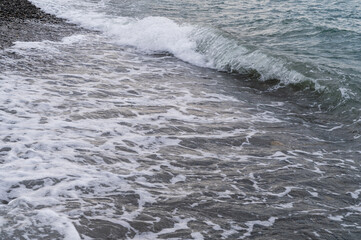 Fototapeta premium Water sea beach. Wave ocean blue. Stone texture reflection sun. Surface coast pebbles. 