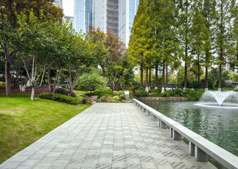 Serene Urban Park Pathway with Lush Greenery and Tranquil Water Feature