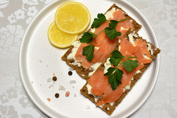 a plate of food with a lemon and a slice of bread with salmon on it
