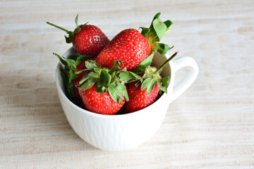 a white ceramic cup with strawberries in it close up 
