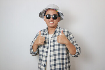 Positive man wear hat beach shirt gentle smile double thumb up.