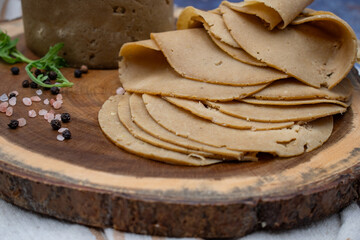 Vegan meat alternative: seitan ham sliced on wooden board